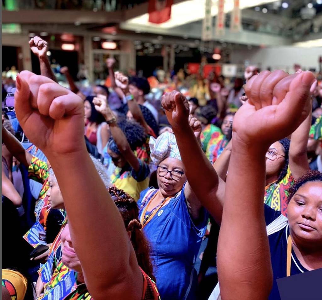 A group of women standing together with raised fists in the air